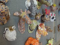 many different animal masks are hanging on the wall