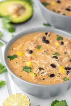 chicken enchilada soup in a bowl with cilantro and lime