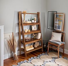 a living room filled with furniture next to a wooden shelf covered in books and magazines