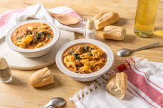 two bowls of pasta soup on a wooden table