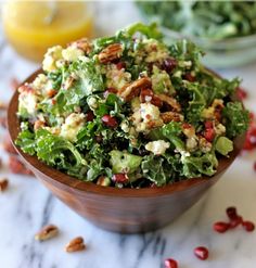 two pictures of a salad in a wooden bowl on a marble table with lemons and pomegranates