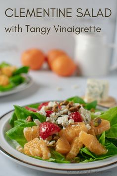 a close up of a plate of food on a table with the title clementine salad with tangy vinaigrete