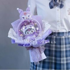 a person wearing a kilt and holding a purple brooch in their left hand