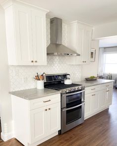 a kitchen with white cabinets and stainless steel appliances