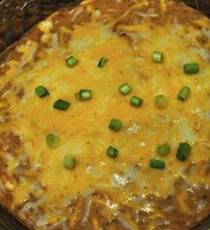 a casserole dish with cheese and green onions on the top is ready to be eaten