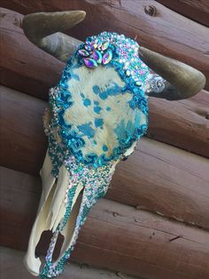 a cow's head is adorned with blue beads and sequins on it