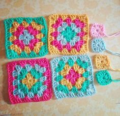 four crocheted squares are arranged on the floor