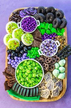 a platter filled with different types of food on top of a purple tablecloth