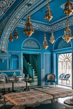 an ornate blue room with chandeliers and rugs on the floor is featured in this post