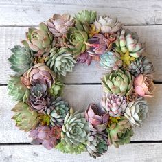 a wreath made out of succulents sitting on top of a wooden table