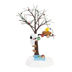 a christmas tree with ornaments hanging from it's branches and a dog on the branch