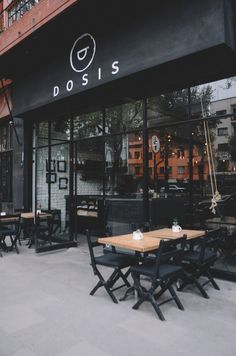 the outside of a restaurant with tables and chairs