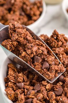 chocolate granola is being spooned into a bowl