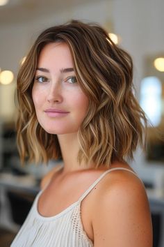 Young woman with wavy shoulder-length hair and a soft smile in a bright, modern room. Short Hairstyles Balayage, Short Layered Haircuts Brunette, Balayage Brown Short Hair, Partial Highlights For Light Brunettes, Mini Baylage Hair, Short Brunette Hair With Lowlights, Brunette Short Balayage Hair, California Brunette Hair Short, Short Highlighted Hair Brown