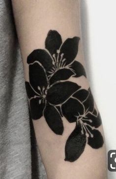 a black and white flower tattoo on the arm