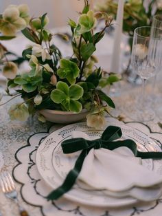 a table set with plates, napkins and flowers