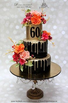 a three tiered cake decorated with flowers and the number 60 on it's side