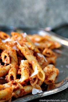 a plate full of pasta with sauce and cheese on the top is ready to be eaten