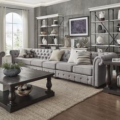 a living room filled with lots of furniture next to a large window covered in bookshelves