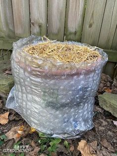 a plastic bag filled with hay sitting on the ground