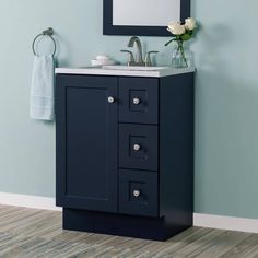 a bathroom vanity with a mirror above it and a towel hanging on the wall next to it