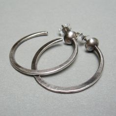 "Silver hoop earrings, I hammered the hoop of wire, then I soldered it to a half silver granule, and to the back, I soldered a pin. They are light, with a simple and clear design, suitable to be worn on many occasions weight 0.10 oz length 1.18\" width1.18\" Simple jewel, but made original by craftsmanship, which adds value and features to each of my pieces. Thank you for visiting my shop, if you like to receive news and updates please save me in your favs you can find me on Instagram; @Petrahje Silver Hand Forged Small Hoop Earrings, Hand Forged Small Hoop Silver Earrings, Silver Hand Forged Hoop Earrings, Hand Forged Silver Hoop Earrings, Sterling Silver Soldered Hoop Earrings, Hoop Earrings Handmade, Hammered Hoop Earrings, Sterling Silver Hoop Earrings, Sterling Silver Hoops