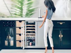 a doll standing in front of an open refrigerator