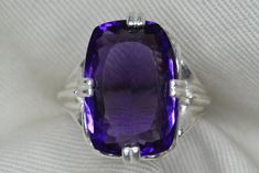 "For sale here is a very high quality amethyst ring. The genuine earth mined amethyst is a vivid purple colour. This size 6 3/4 ring is made of solid sterling silver and can be sized up or down by as much as 2 sizes for $25. This item is brand new and was appraised by a gemologist at Canadian Federal Gemological Laboratory of Canada.  The appraisal will be included with the item. The amethyst is described in the appraisal as follows:  \"Shape and cut: Rectangular Weight: 10.54 ct Species: Natural Quartz Variety: Amethyst Colour: Purple Transparency: Transparent Luster: Vitreous Refractive Index: 1.55 - 1.56 Identifying characteristics: Internal M.S.R.P: $740.00 CAD\" Please feel free to browse my shop for hundreds of additional pieces of certified gemstone jewelry including an excellent se Faceted Purple Amethyst Ring For Formal Occasions, Formal Faceted Purple Amethyst Ring, Classic Large Stone Amethyst Ring For Formal Events, Formal Faceted Amethyst Ring, Classic Formal Amethyst Ring With Large Stone, Classic Purple Amethyst Ring With Polished Finish, Formal Amethyst Ring With Large Stone, Classic Polished Amethyst Gemstones, Classic Purple Amethyst Ring