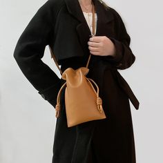 Add a touch of understated elegance to your ensemble with the Amber-Leather Pouch-Bag. This versatile handbag, crafted from high-quality leather, boasts a unique pouch design with knotted details for an effortlessly chic look. The warm amber hue complements any outfit, making it a perfect accessory for both casual and formal occasions. With its adjustable strap, you can carry it as a shoulder bag or crossbody for hands-free convenience. Spacious enough to hold your essentials, this stylish pouch-bag combines functionality with fashion, making it an essential addition to your accessory collection. Chic Leather Mobile Phone Pouch, Fall Soft Leather Clutch Bag, Chic Soft Leather Pouch Phone Bag, Trendy Fall Soft Leather Bucket Bag, Elegant Hobo Bag With Mobile Phone Bag For On-the-go, Chic Tote Pouch For Mobile Phone, Chic Tote-style Mobile Phone Pouch, Chic Solid Color Bucket Bag With Phone Pocket, Chic Soft Leather Phone Bag For Everyday Use