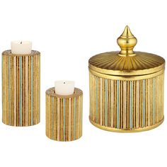 three gold and blue striped canisters next to each other with a candle in the middle