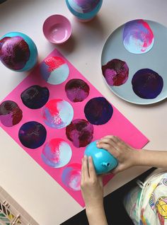 a child is playing with paper plates on the table