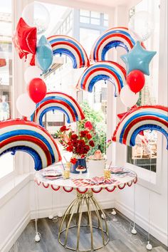 a table with balloons and flowers on it