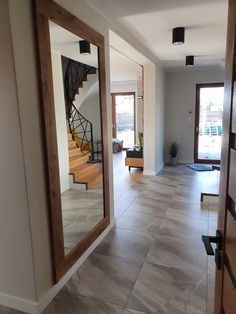 an empty room with stairs and mirrors on the wall, in front of a door