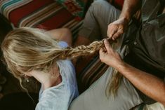 a woman is braiding another woman's hair