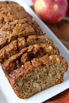 a loaf of bread sitting on top of a white plate next to an apple pie