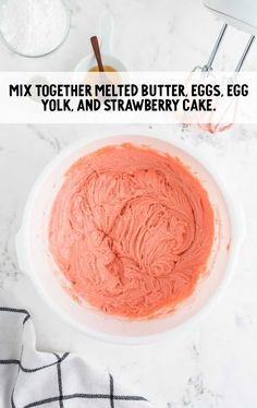 a white bowl filled with pink cake batter on top of a counter next to other ingredients