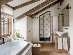 a white bathroom with two sinks and a bathtub next to a wooden counter top