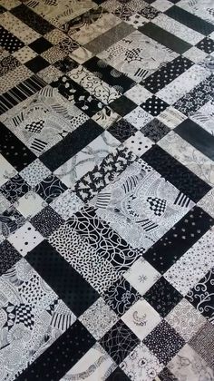 a black and white patchwork quilt is laying on the floor