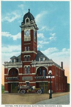 an old building with a clock tower on top and people standing in front of it