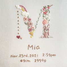 a cross stitch pattern with the letter m and an image of a bunny holding a flower