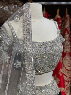 Iced cube sliver lehenga with frosted crystal embroidery teamed with a spaghetti strap blouse with crystal embroidery and net dupatta. Fabric: Net Custom designed according to client measurements and color preference. Production and delivery time is 120 days! Sliver Lehenga, Chaniya Choli For Sangeet, Glamorous Embellished Silver Set, Glamorous Silver Sets For Festive Season, Glamorous Silver Festive Sets, Glamorous Festive Silver Set, Silver Party Wear Sets With Intricate Embroidery, Silver Traditional Drape Choli For Party, Silver Party Choli With Traditional Drape