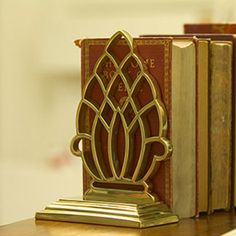 an old book is sitting on a shelf next to two books and a candle holder