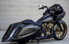 a black motorcycle parked next to a brick wall