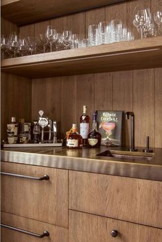 the shelves in this kitchen are filled with glasses and liquor bottles, including an old fashioned decanter