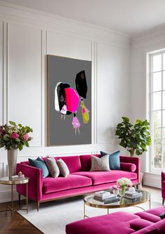 a living room with pink couches and paintings on the wall