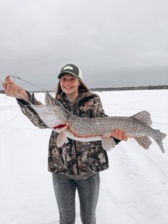 a woman holding a fish in the snow