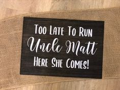 a wooden sign that says, too late to run uncle matt here she comes on the floor