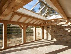 an empty room with large windows and stone walls, in the middle of a sunny day