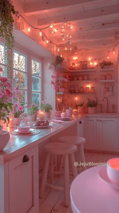 a kitchen filled with lots of counter top space and lights hanging from the ceiling above it