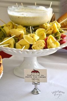 pasta and vegetables on skewers with dip in the middle for dipping at a wedding reception